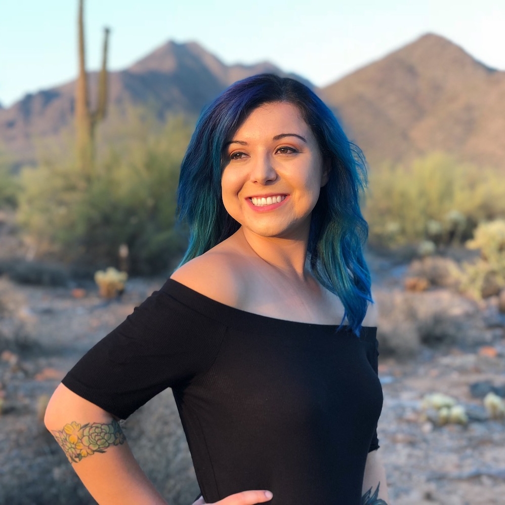 Savanah Pennell with blue hair stands in the desert